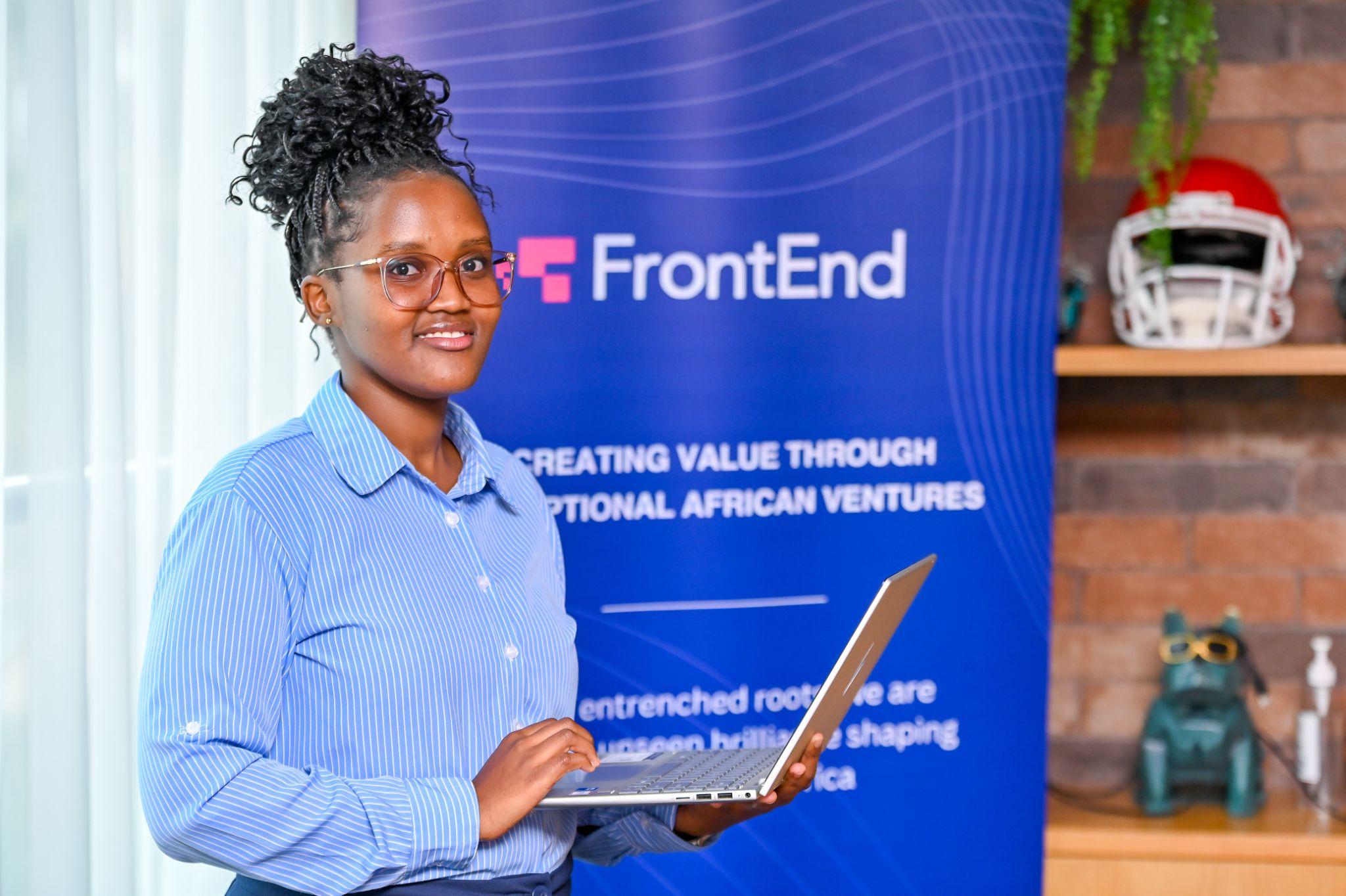 Woman with glasses in a blue striped shirt holding a laptop in front of a FrontEnd banner.